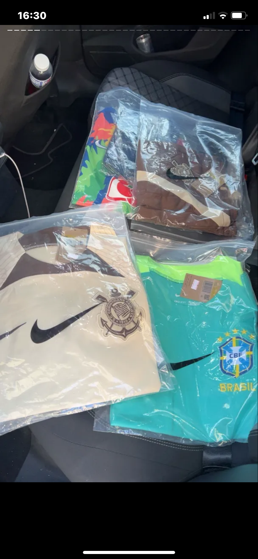 Klantfoto van meerdere ingepakte shirts in een auto